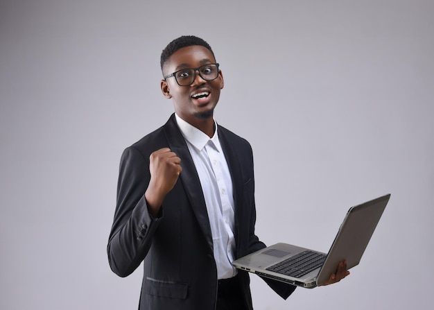 african man wearing glasses black suit holding laptop excited smile premium photo